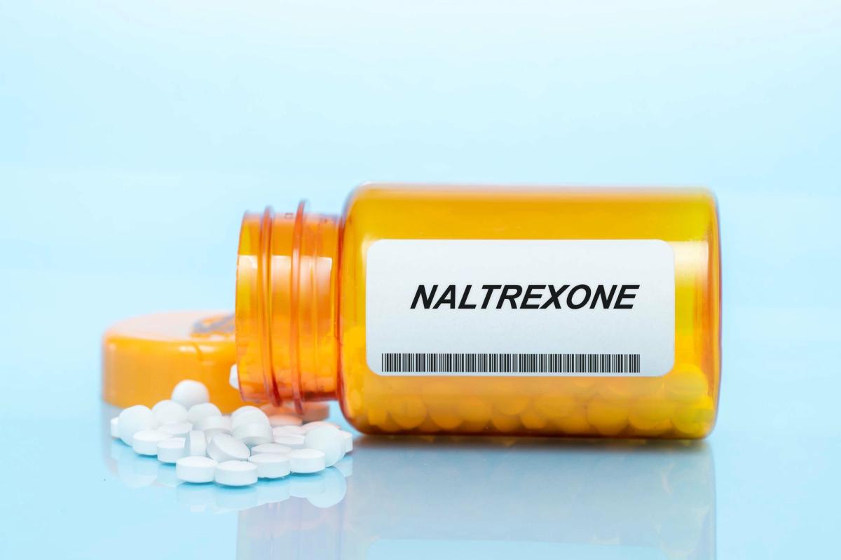 A pill bottle labeled "Naltrexone" tipped over.