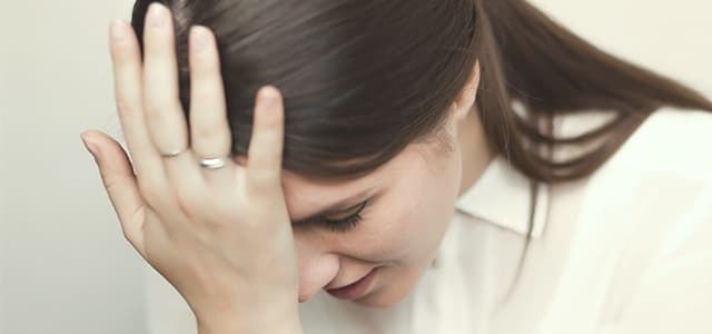 Person showing signs of distress with hand to head