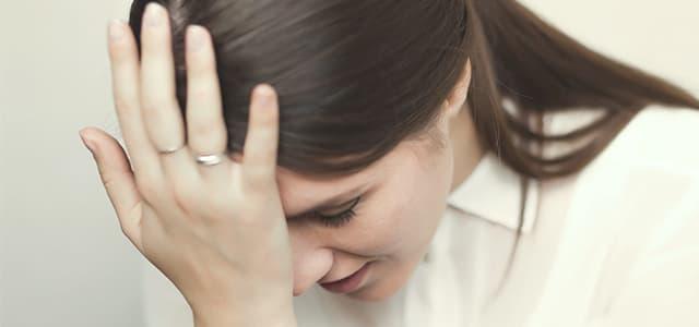 Person showing signs of distress with hand to head