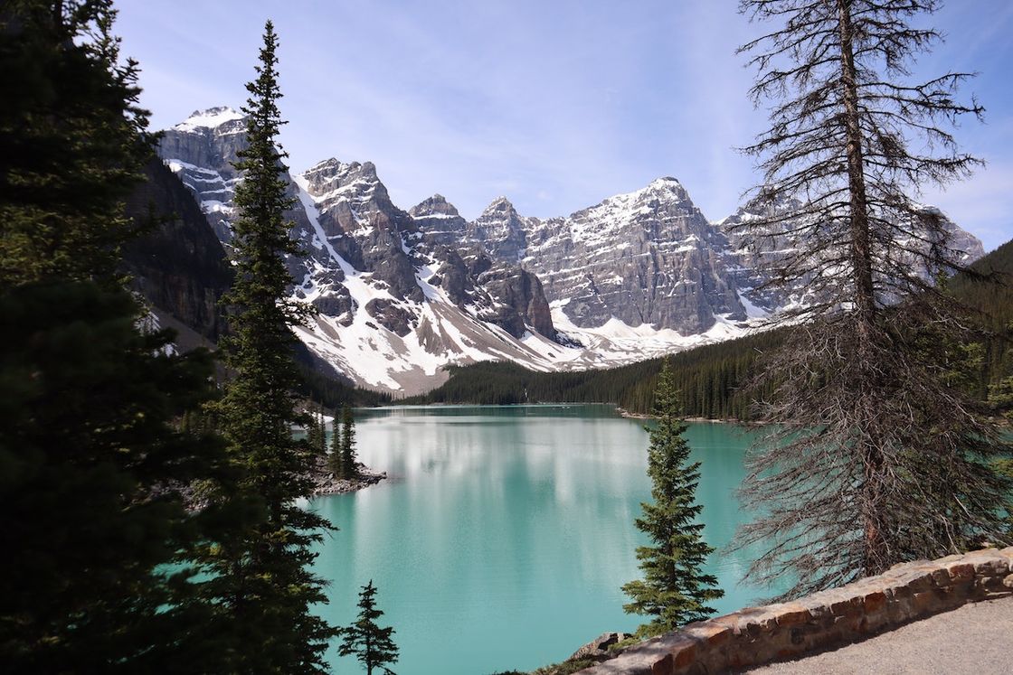 Mountain lake surrounded by evergreen forest in Canada where outdoor-focused rehab centers offer treatment