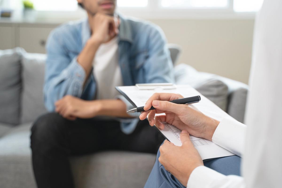 Therapist holding a clipboard and pen during an intake assessment with a client, representing same day rehab and immediate access to addiction treatment services.