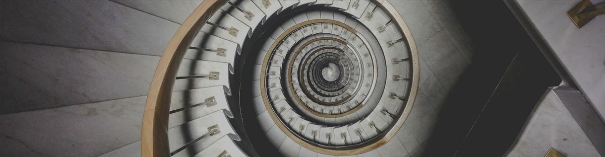 Overhead view of spiral staircase descending into center, representing the psychological depth explored in ketamine and psychedelic therapy for depression