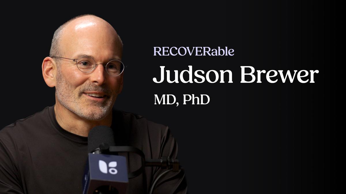 A high-contrast studio portrait against a solid black background featuring Dr. Judson Brewer.