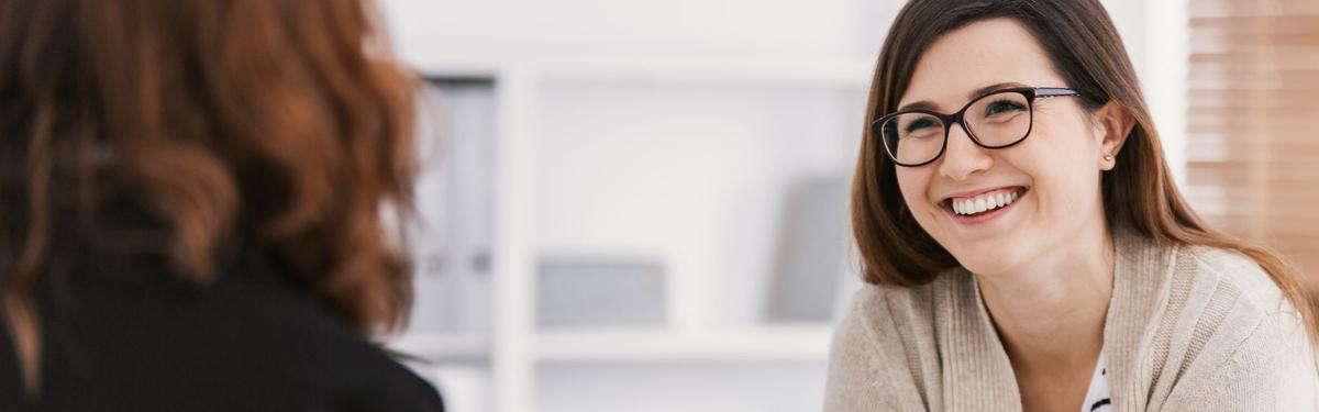 A therapist smiling at a patient receiving care for mental health.