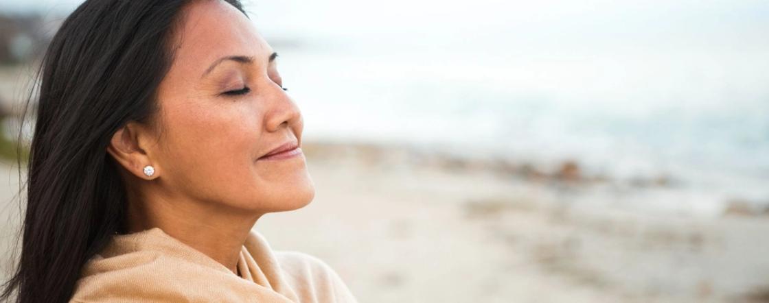 Woman practicing calming breathing exercise outdoors for panic attack relief