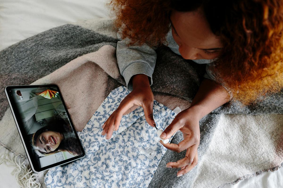 Woman with red curly hair at home on video call receiving sobriety support during early recovery