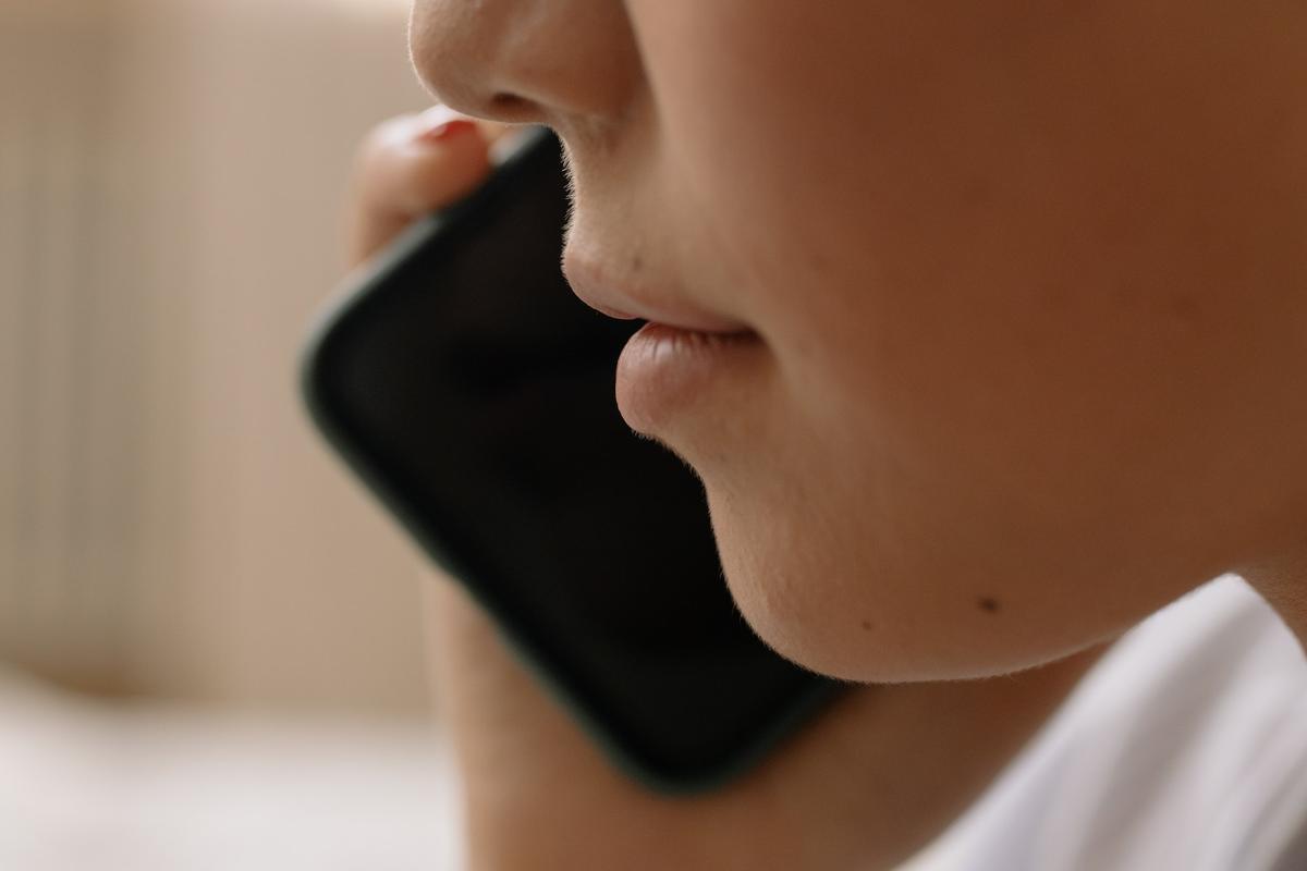 Person holding cell phone during phone call in rehab treatment center