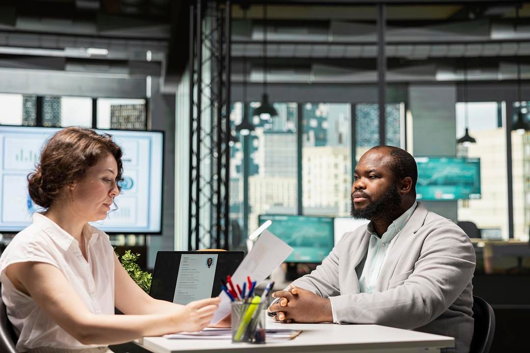 Professional Job Interview in Modern Office Setting | Recruiter Reviewing Candidate Resume During Corporate Hiring Meeting