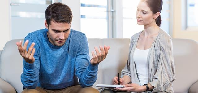 Man in distress during behavioral health therapy session with counselor at dual diagnosis treatment center