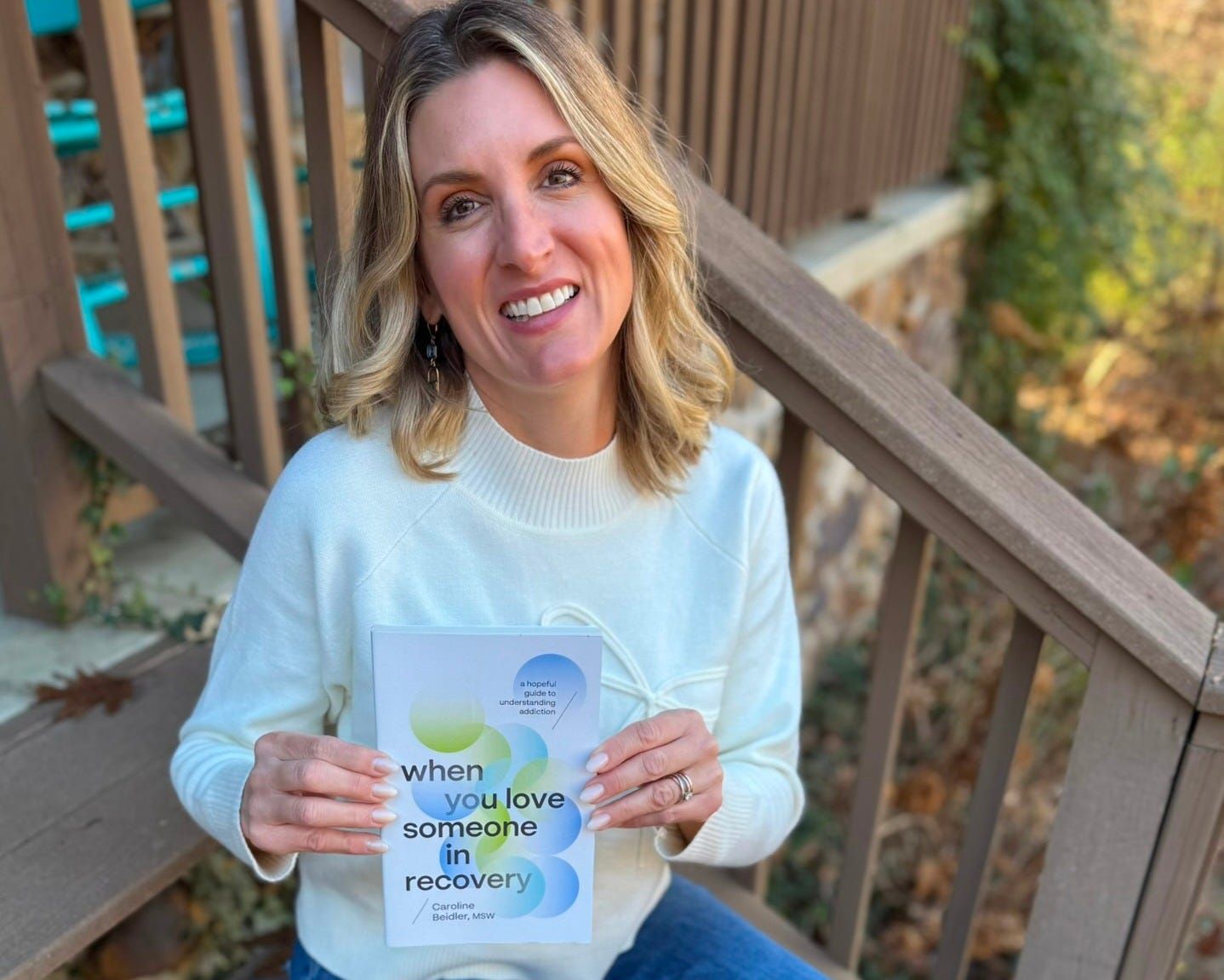 Caroline Beidler, MSW, holding her book 'When You Love Someone In Recovery'