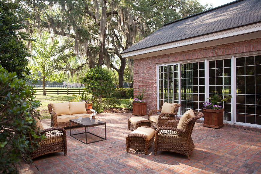 Elegant outdoor therapy space at luxury treatment center with comfortable seating under mature oak trees