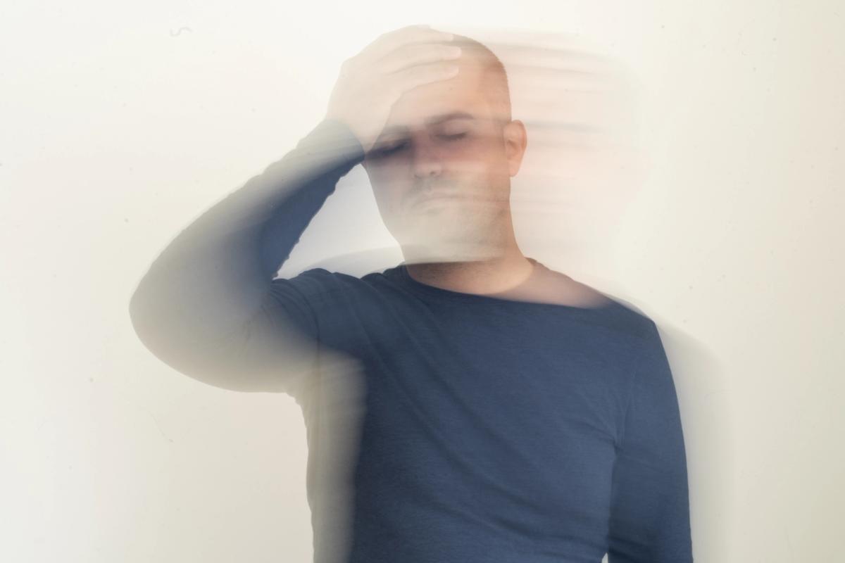 Blurred motion image of person with hand on head, representing the cognitive impairment and disorientation from mixing alcohol and benzodiazepines