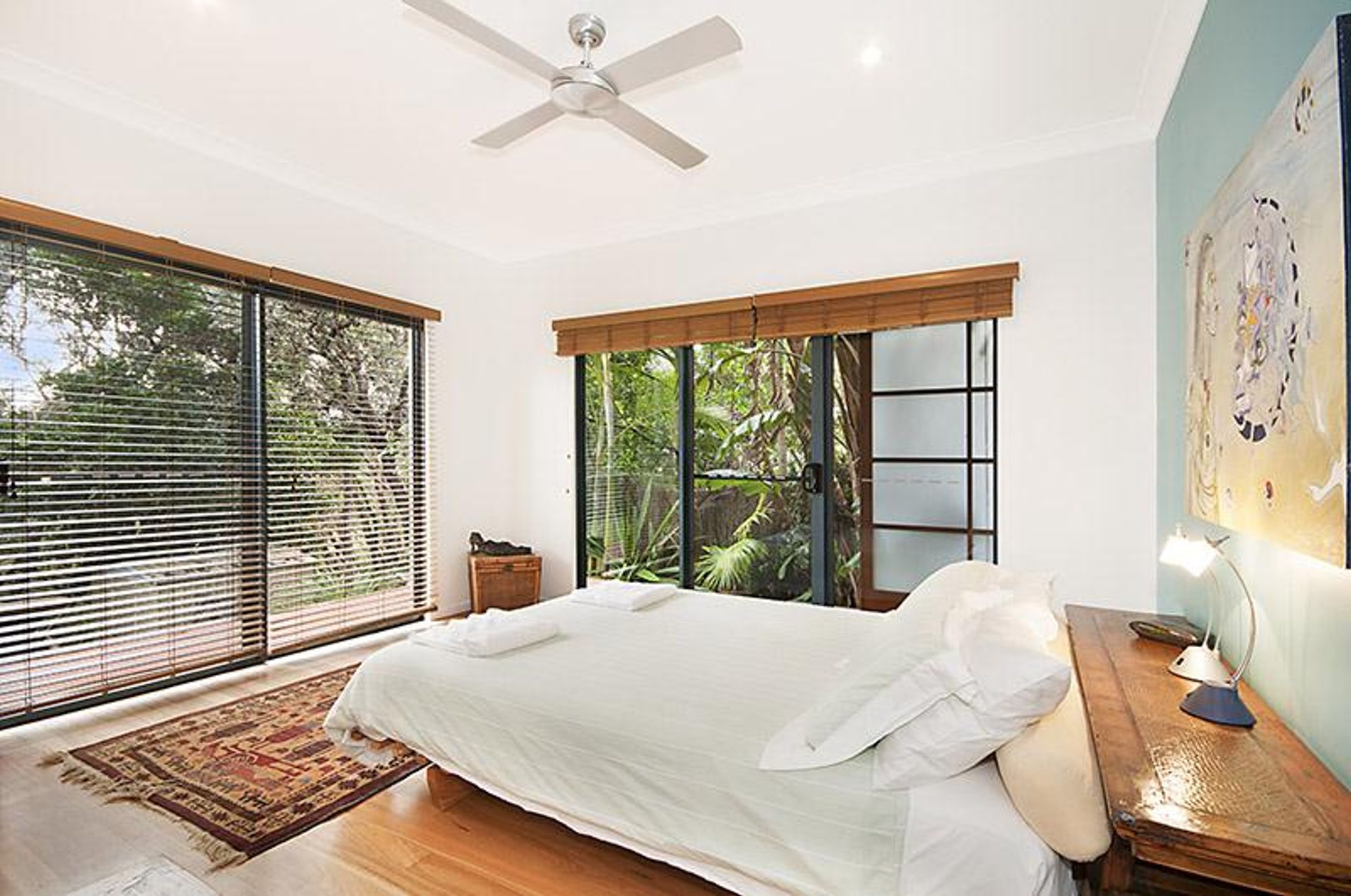 Serene bedroom at luxury rehab center with natural lighting and garden views