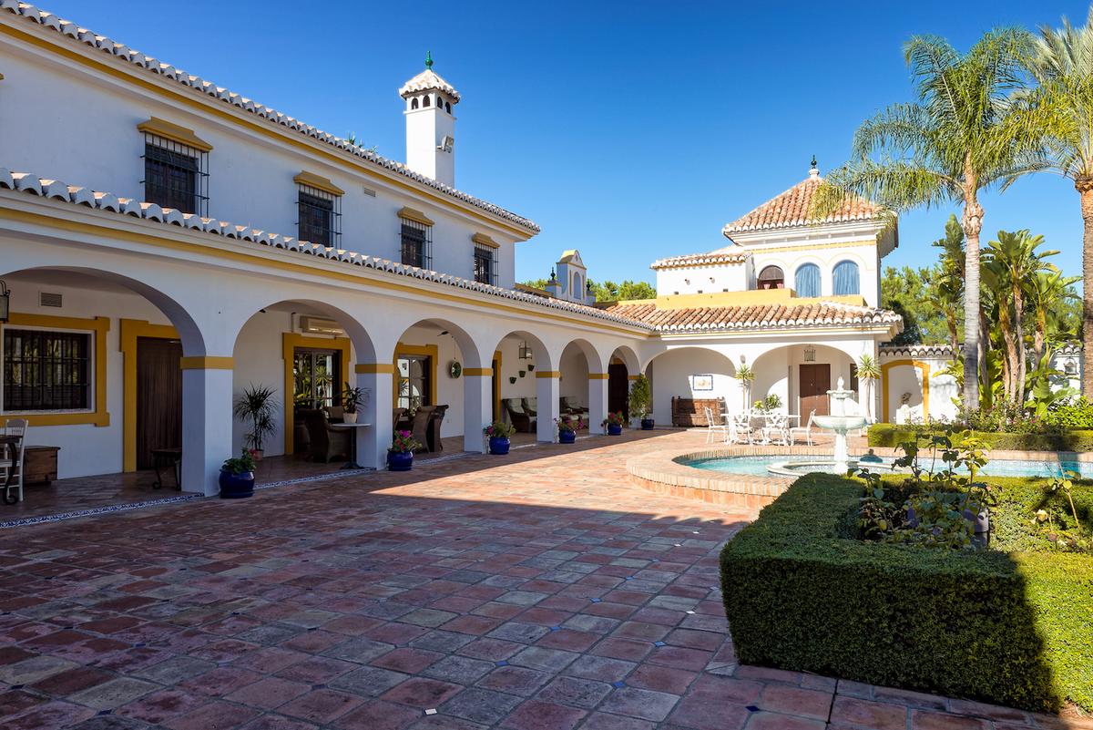 Spanish-style residential rehab facility courtyard with pool and palm trees, showcasing the serene healing environment of inpatient addiction treatment