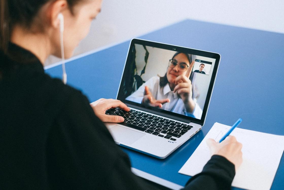 Patient participating in an online aftercare therapy session via video call on laptop