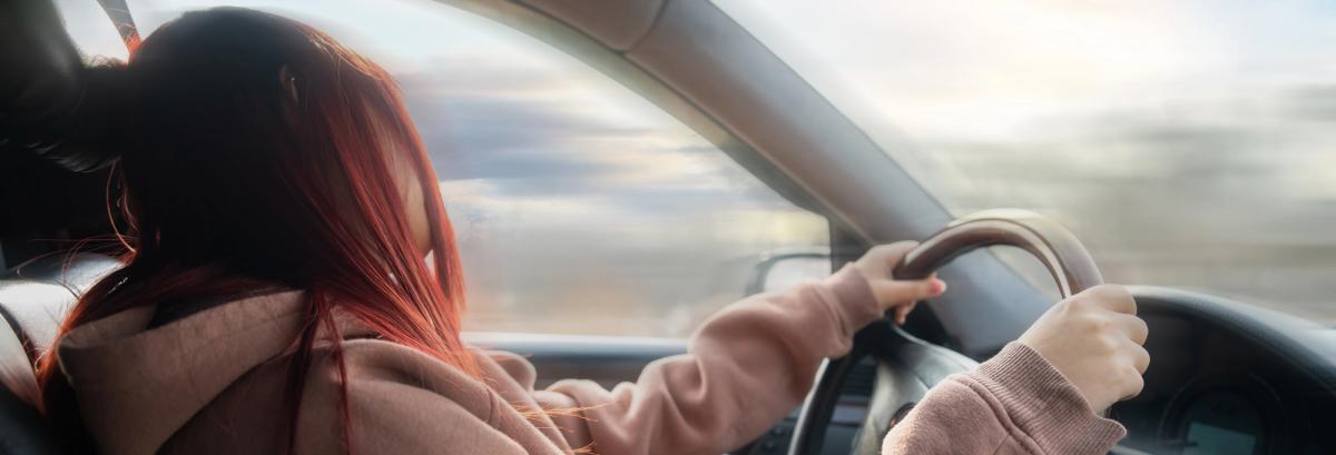Person driving with head drooping toward steering wheel, representing extreme drowsiness and impaired judgment associated with mixing opioids and stimulants