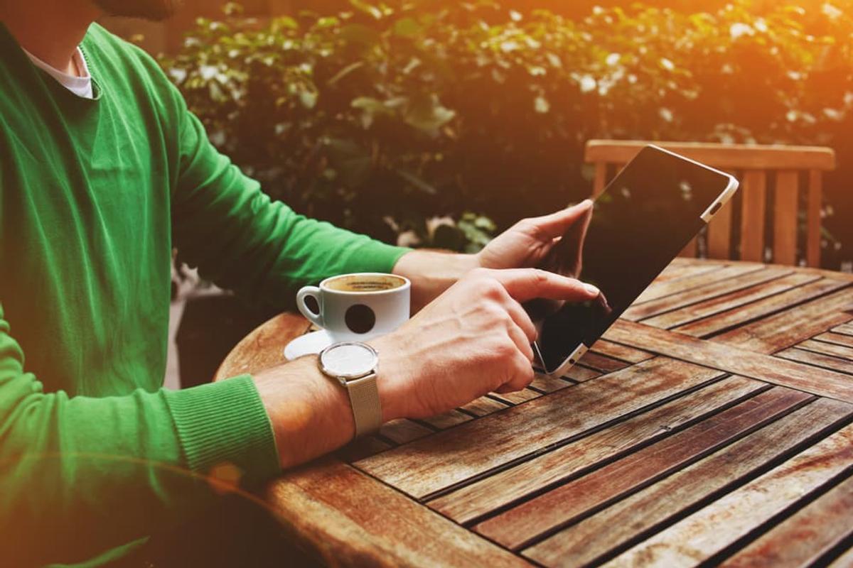 Someone using smartphone recovery app during peaceful morning supporting long-term sobriety