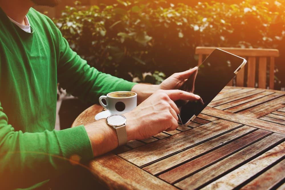 Someone using smartphone recovery app during peaceful morning supporting long-term sobriety