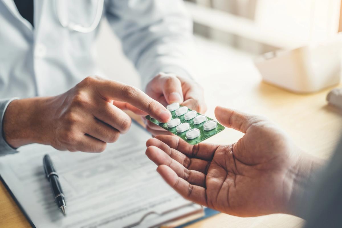 Healthcare provider handing prescription medication to patient, illustrating how barbiturates are prescribed for legitimate medical use but carry addiction risks
