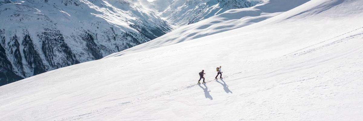 Two people snowshoeing up a snowy mountain slope in Colorado Rockies, illustrating the outdoor adventure therapy activities at Colorado treatment centers