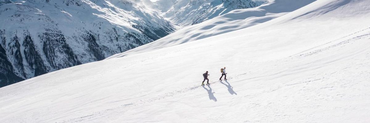 Two people snowshoeing up a snowy mountain slope in Colorado Rockies, illustrating the outdoor adventure therapy activities at Colorado treatment centers