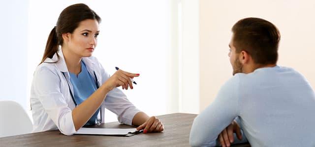 A patient sitting at a table with their doctor.