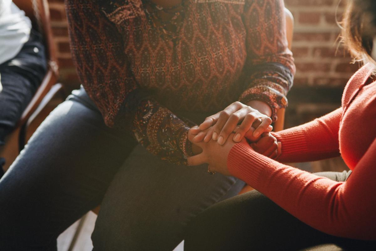 Women holding hands in a supportive circle, symbolizing connection, compassion, and empowerment in Women for Sobriety recovery and peer support.