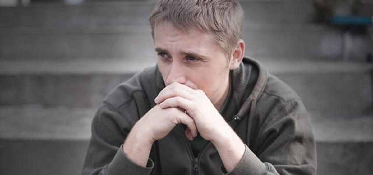 Young person looking worried and contemplative, struggling with carisoprodol addiction and considering treatment options